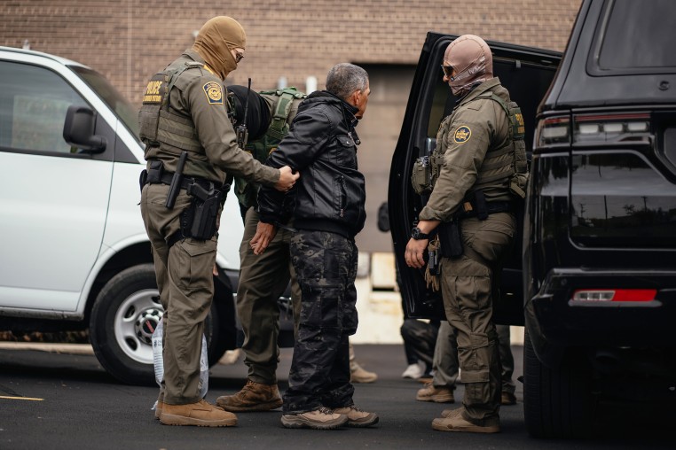Immigration and Customs Enforcement agents take people they detained earlier to a parking lot before transferring them to an ICE facility in Chicago.