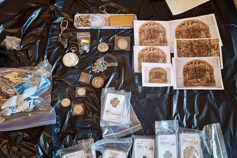 overhead view of An assortment of jewelry, keys, coins, and photo prints laid on a surface