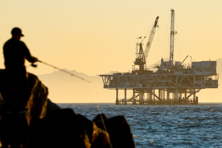 A person fishes with offshore oil and gas platform in California. 