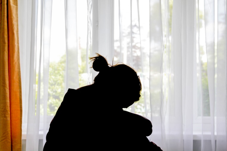 Silhouette of a woman in front of the window.