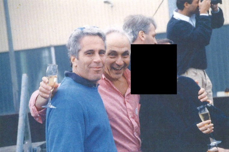 Jeffrey Epstein, Les Wexner and a person who has been redacted pose together in an undated photo.