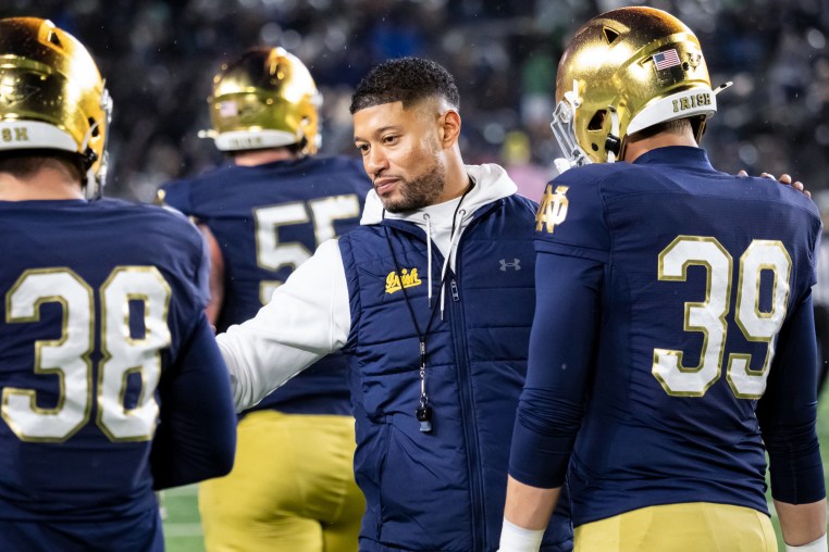 Marcus Freeman greets players on the football field
