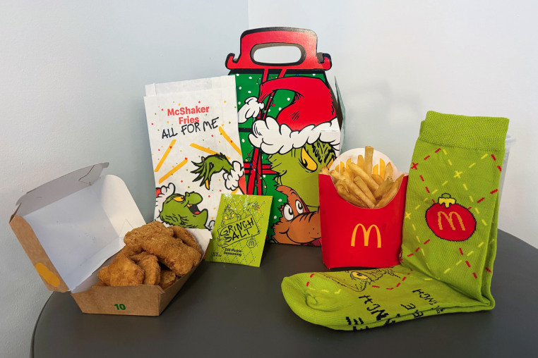 McDonald's Chicken Nuggets, a green packet of Grinch Salt, french fries, green Grinch socks displayed on a table