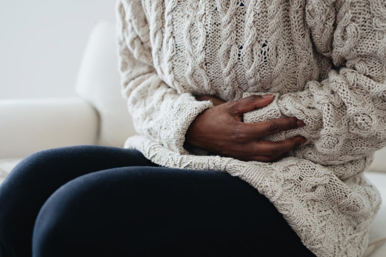 Woman Holds Abdomen in Pain