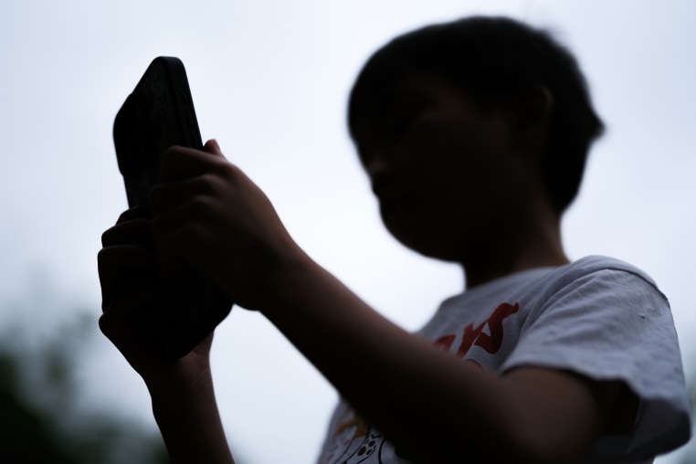 A 7-year-old teenage boy looks at a phone screen on December 7 in Sydney, Australia.