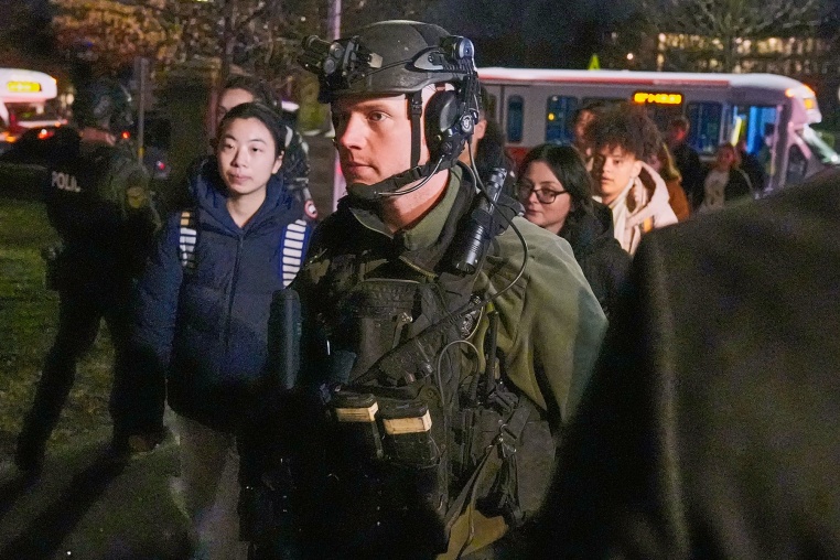 Students are escorted by law enforcement officers to a building at Brown University after a shooting, Saturday, Dec. 13, 2025, in Providence, R.I.. 