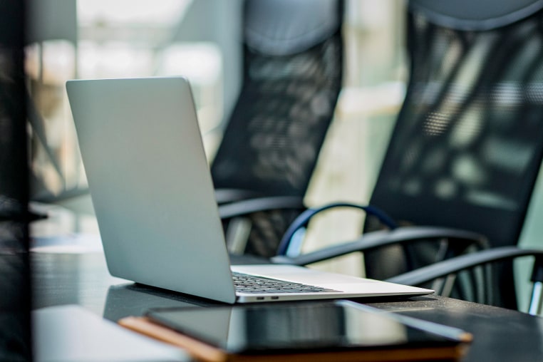 Open laptop kept on table near digital tablet