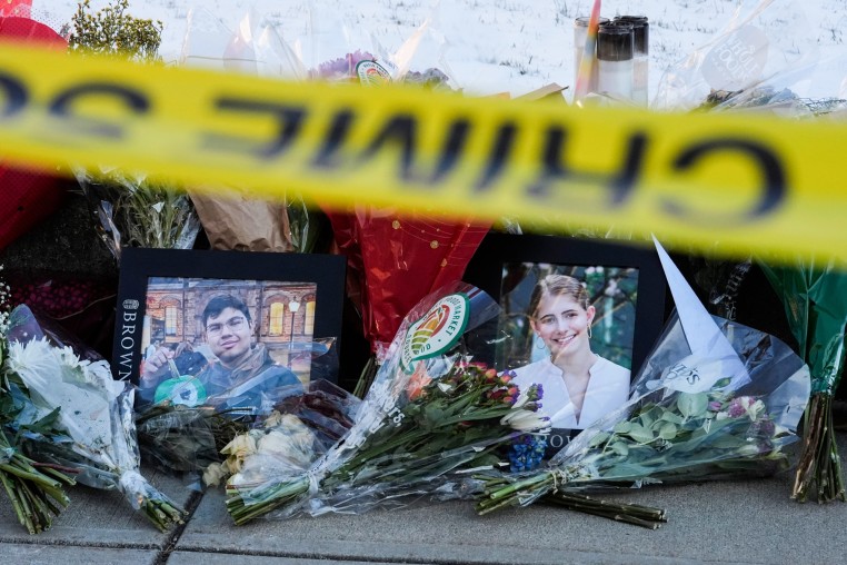 Photos of MukhammadAziz Umurzokov, left, and Ella Cook, are seen amongst flowers at a makeshift memorial outside on a sidewalk