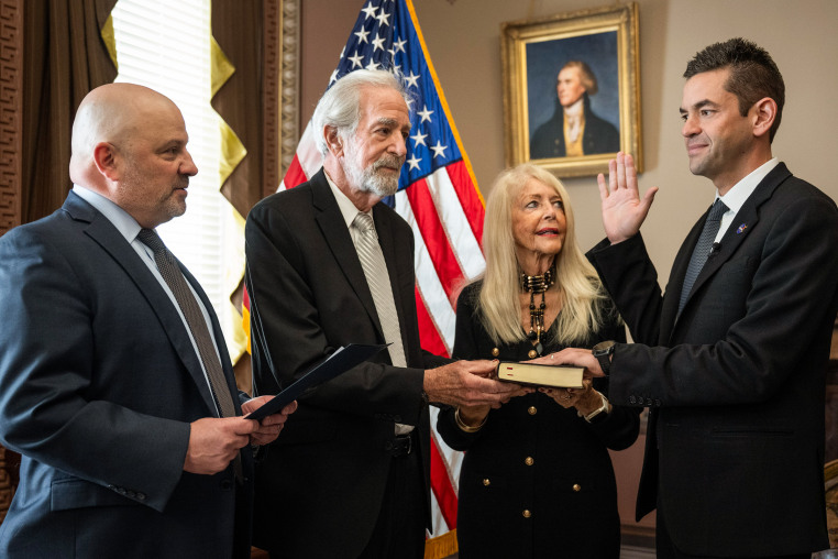 U.S District Judge Timothy Kelly, left, swears in Jared Isaacman, right, as 15th administrator of NASA, as Isaacman's parents, Donald and Sandra Marie join, on December 18, 2025 in Washington D.C.