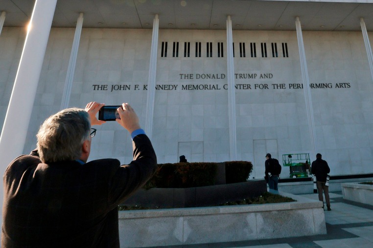 A man photographs the updated lettering outside the Kennedy Center after "Donald J. Trump" was added on Dec. 19, 2025.