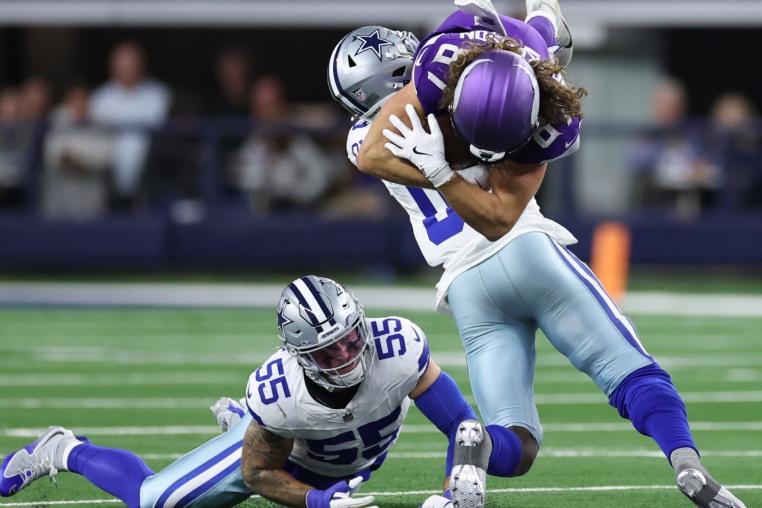 ARLINGTON, TEXAS - DECEMBER 14: T.J. Hockenson #87 of the Minnesota Vikings is tackled by Demarvion Overshown #0 of the Dallas Cowboys during the fourth quarter at AT&T Stadium on December 14, 2025 in Arlington, Texas. (Photo by Stacy Revere/Getty Images)