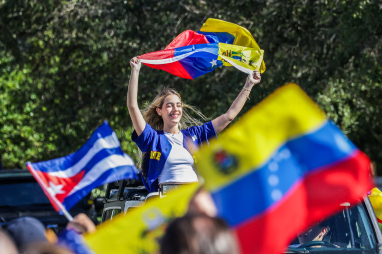 People wave Venezuelan flags outside