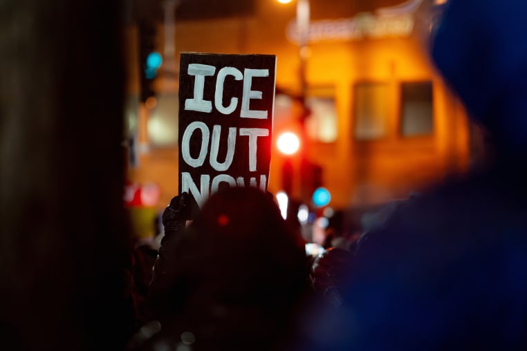 A demonstrator carries a sign during a protest in Minneapolis, Minn. on Thursday.