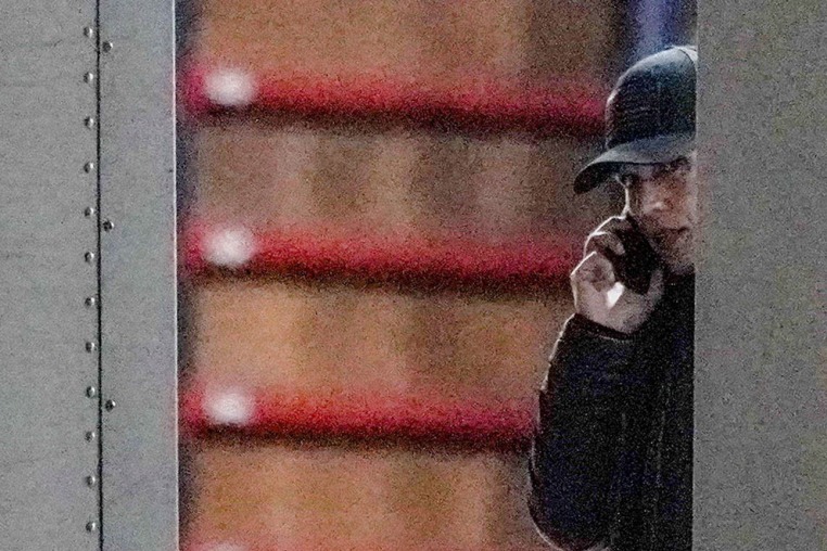 Director of National Intelligence Tulsi Gabbard speaks on the phone while standing inside a vehicle loaded with boxes outside the Fulton County Election Hub and Operation Center in Union City, Ga., on Jan. 28, 2026.