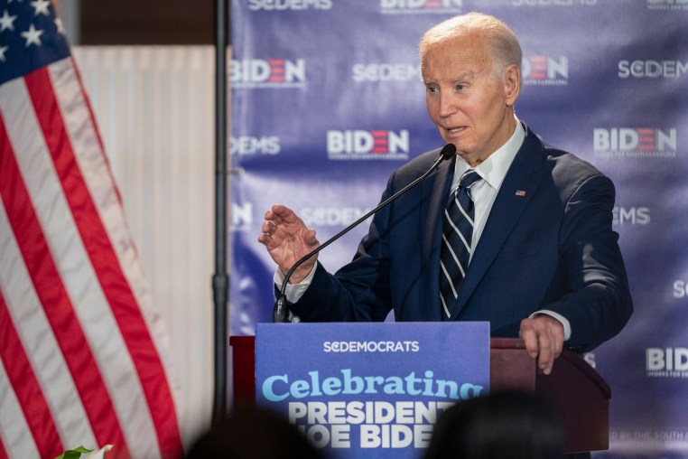 Former President Joe Biden speaks to a crowd from a podium.