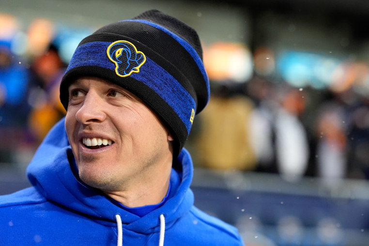 Mike LaFleur smiles as he looks over his right shoulder. He's wearing the blue team colors of the L.A. Rams and a stocking cap.