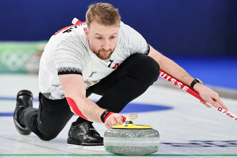 Yannick Schwaller throws a stone on the ice