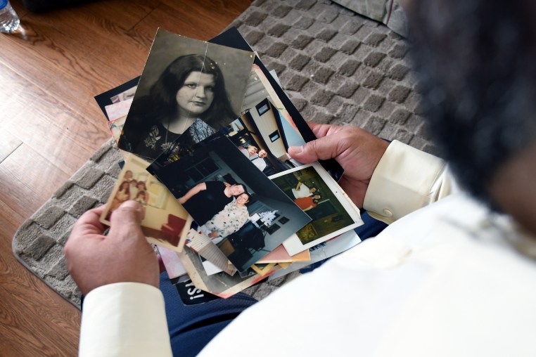 Derrick Johnson, whose mother's body was one of 189 left to decay in the Return to Nature Funeral Home in Penrose, Colo., holds photos of her in Colorado Springs, Colo., on Thursday, Feb. 5, 2026.