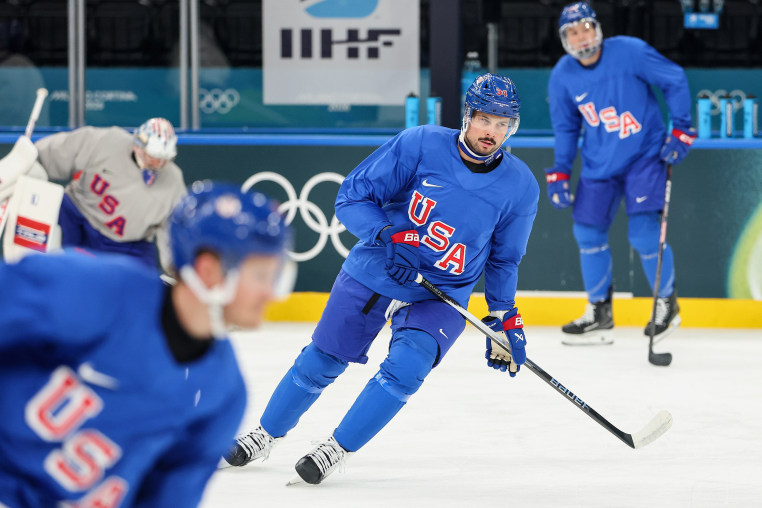 Auston Matthews holds a hockey stick with both hands while skating on the ice. 