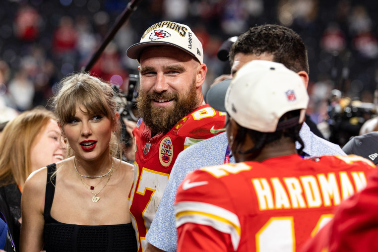Travis Kelce and Taylor Swift together on the football field following a Kansas City Chiefs game