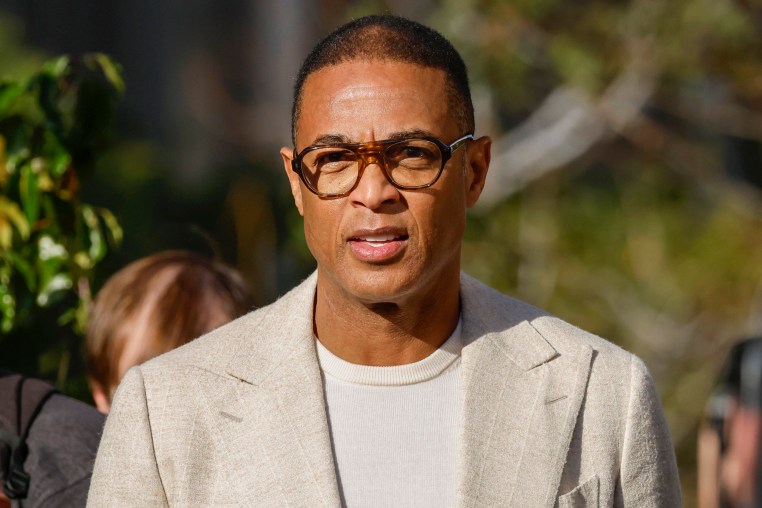 Television Journalist Don Lemon walking outside court while wearing a beige suit and thin sweater. 