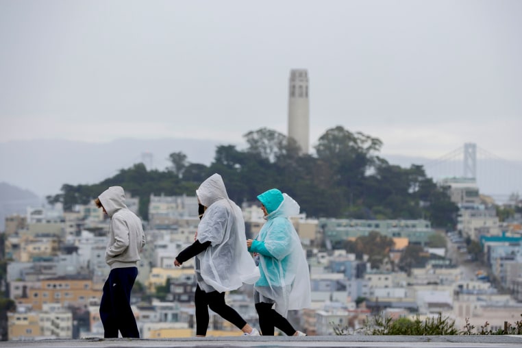 People wear rain ponchos;
