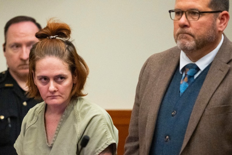 Rebecca Auborn standing in court next to a lawyer and police officer.