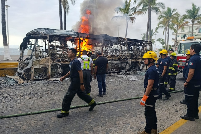 Firefighters work to extinguish flames from buses allegedly set on fire by members of organized crime in Puerto Vallarta, Mexico, on Feb. 22, 2026. 