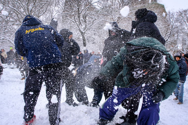 People participate in a snowball fight.