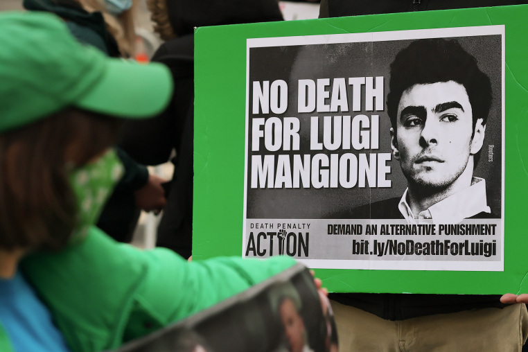 A black and white sign reads NO DEATH FOR LUIGI MANGIONE.