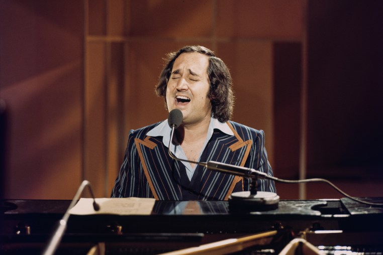 Neil Sedaka plays the piano and sings.