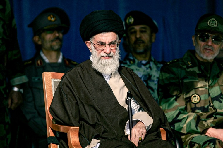 Ayatollah Ali Khamenei on a stage with army personnel.