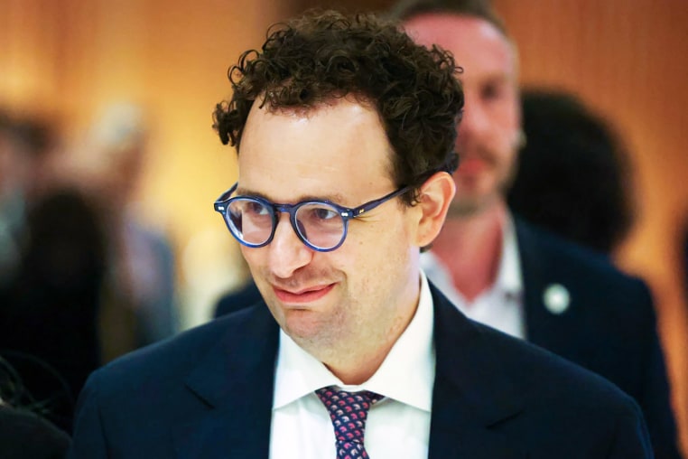 Anthropic CEO Dario Amodei looks smiles as he appears to be walking.