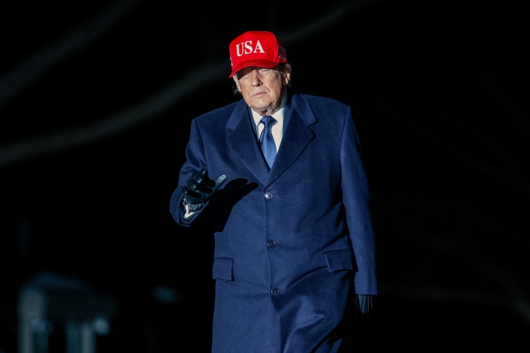 Donald Trump walks outside at night