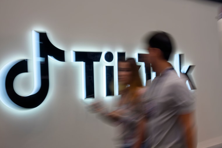 Web Summit attendees walk past the TikTok pavilion