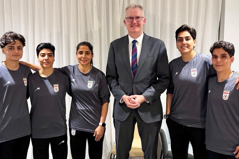 Australia's Home Affairs Minister Tony Burke poses with Fatemeh Pasandideh, Mona Hamoudi, Atefeh Ramezanizadeh, Zahra Ghanbari and Zahra Sarbali, the five women from the Iranian women’s soccer team who were granted humanitarian visas, in Queensland, Australia, March 9, 2026.