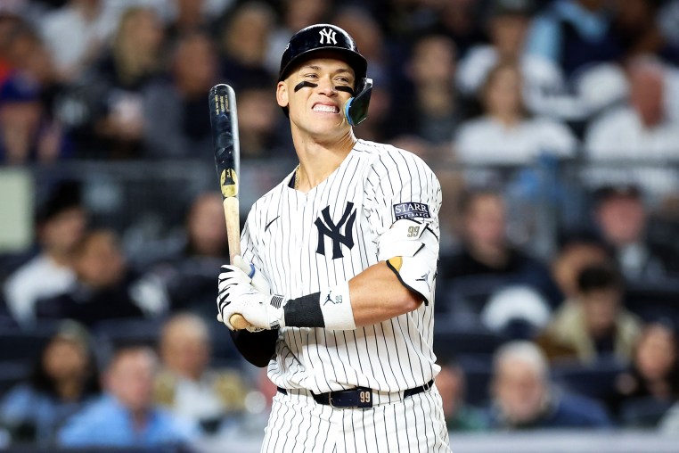 Aaron Judge holds a baseball bat on the field