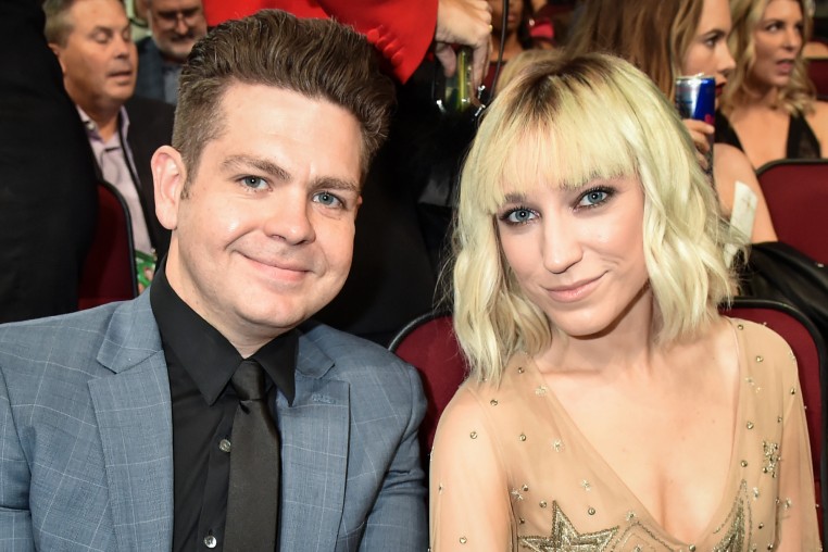 Jack Osbourne and Aree Osbourne smile for a portrait together while seated