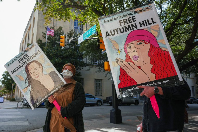 People hold signs in the street.