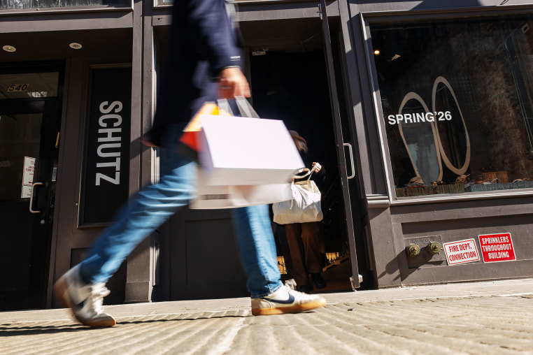 People walk along Broadway with shopping bags in New York on February 27, 2026.