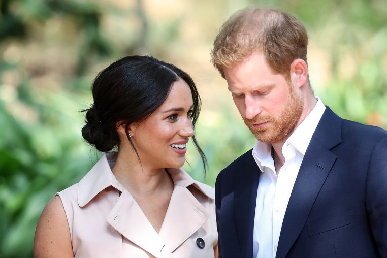 Meghan Markle, left, speaks to Prince Harry on her right