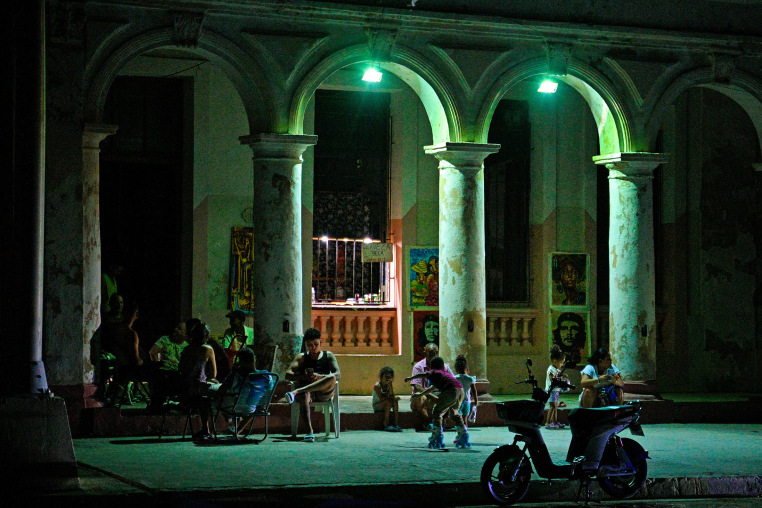 Cubans gather in front of their houses during a blackout in Havana.