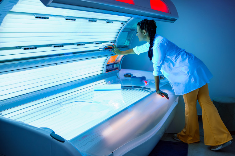 Woman prepares a tanning bed/solarium for sunbathing