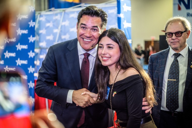 Former television actor Dean Cain poses with an attendee at CPAC in Grapevine, Texas on March 26, 2026.