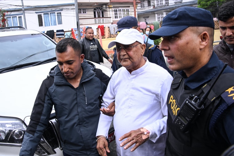 Nepal's former prime minister KP Sharma Oli is escorted by police following his arrest in Kathmandu on March 28.