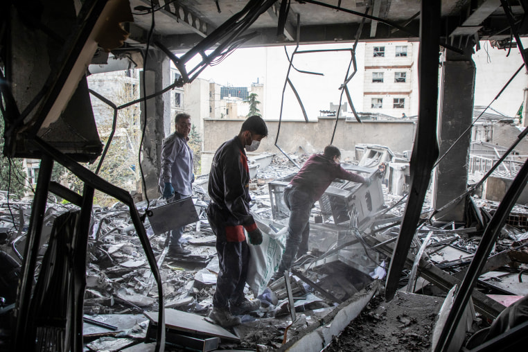 People work to recover items from a building hit by a strike