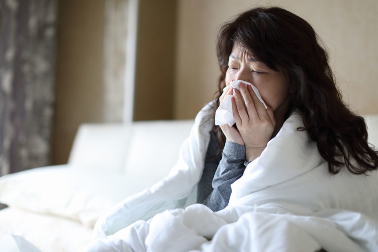 Sick woman blowing her nose