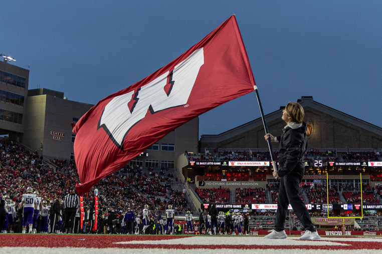 A University of Wisconsin cheerleader waves the school's during a game in 2025.