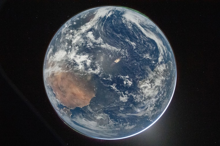 Earth from the Orion spacecraft’s window after completing the translunar injection burn.
