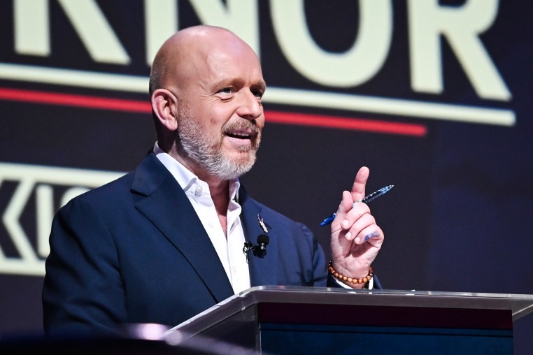 Steve Hilton speaks at a podium on stage